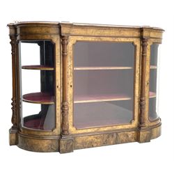 Victorian figured walnut credenza, the curved stepped moulded top with brass gallery above frieze inlaid with box wood motifs, central glazed door flanked by two curved glazed doors, the interior fitted with shelves and lined with red velvet, fluted and acanthus carved column pilasters, figured plinth base