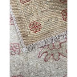 Persian design pale ivory ground carpet, decorated with stylised plant and leaf motifs in pale red
