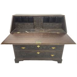 18th century heavily carved oak bureau, the fall front relief carved with three arches enclosing plants and flower head decoration, the interior fitted with pigeonholes, drawers and cupboard, four graduating cock-beaded drawers below, carved with lunettes and trailing foliage decoration, on bracket feet