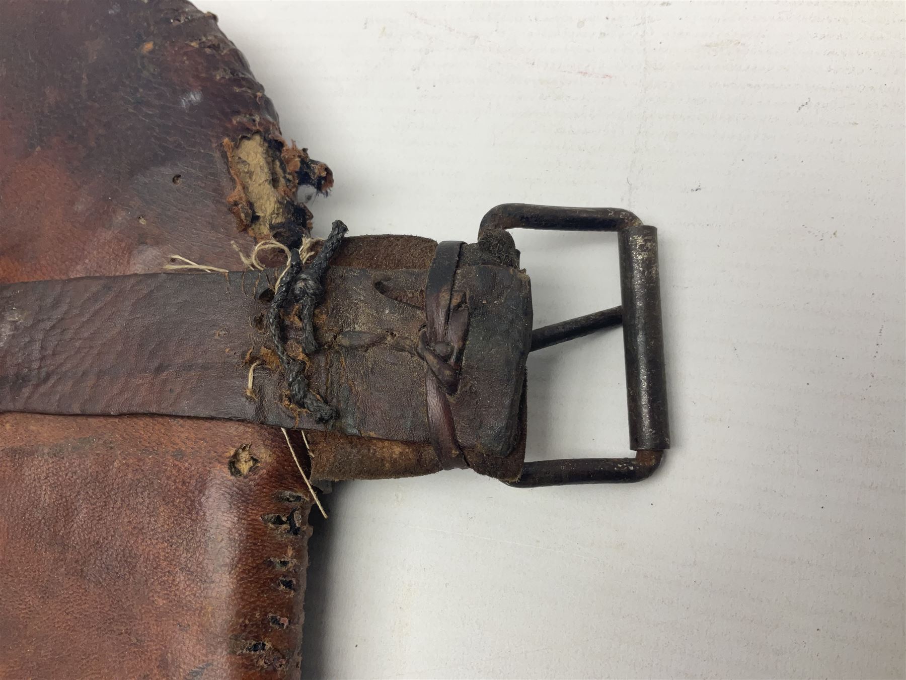 Eastern Jambiya, the 19cm double edge steel blade with raised medial ridge, waisted horn grip with pique work and white metal band; in stitched leather scabbard L33cm overall
