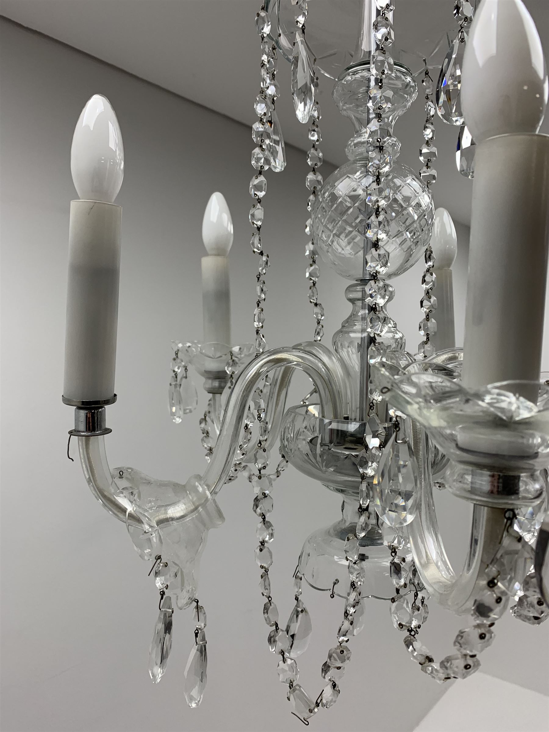 A glass chandelier, with five curved branches with drip pans and droppers, approximately H69cm. 