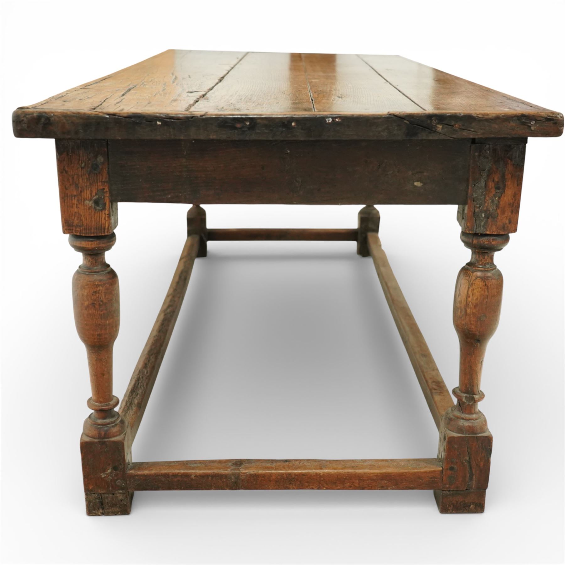 Late 17th to early 18th century oak joint refectory dining table, rectangular four plank top, raised on turned baluster legs, united by chamfered stretchers