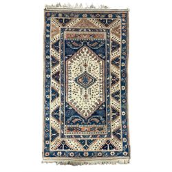 Small Persian blue and ivory ground rug (182cm x 105cm); Persian design rug decorated with Gul motifs (187cm x 134cm); peach ground rug (226cm x 167cm); and a smaller peach ground rug (178cm x 120cm)