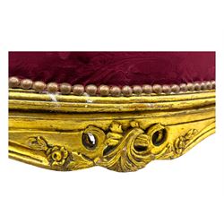 Pair of Louis XV-design giltwood stools, each upholstered in red damask fabric with slight variations in patterns, the carved frames adorned with scrolling foliage and shell motifs, raised on cabriole supports