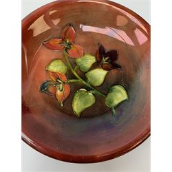 A Moorcroft flambe dish, circa 1950, decorated in the Bougainvillea pattern, marks beneath obscured by glued on fabric hanger, D19cm. 