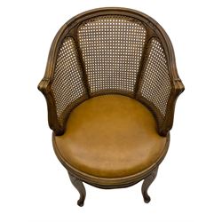 Louis XV style bergère and beech framed swivel desk chair, with brown leather upholstered seat, on four cabriole supports