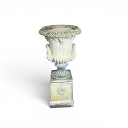 Cast stone classic garden urn, the rim decorated with leaves and berries, twin handles with face masks, raised on square base, stamped HGC