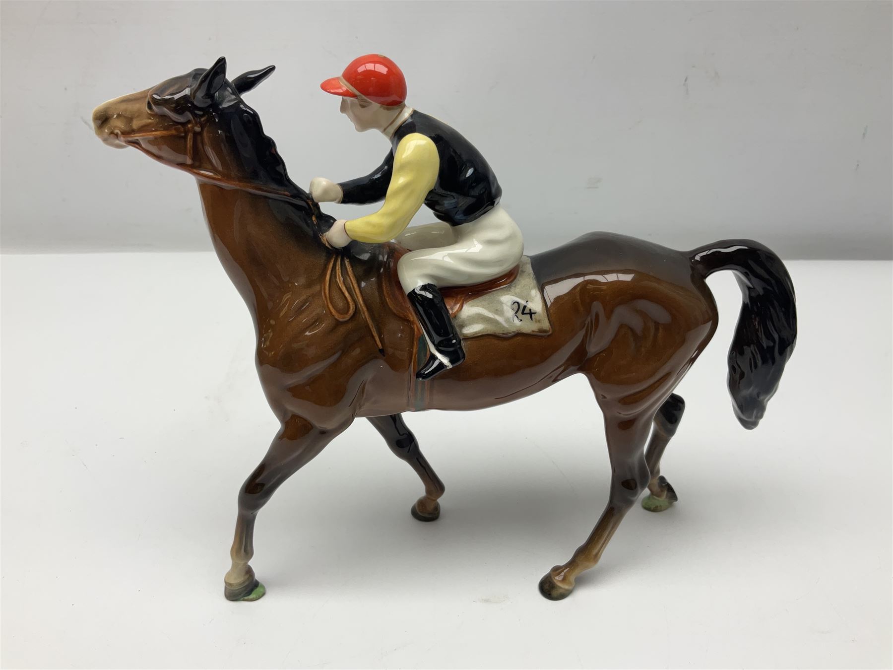 Beswick jockey on walking horse no 1037, in black white and yellow jockey colours, with printed mark beneath, H22cm
