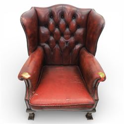 Georgian design wingback armchair upholstered in oxblood leather, the deep button upholstered back with shaped wings and out-scrolled arms, close nailhead trim to the edges, over a loose seat cushion, raised on cabriole front supports terminating in claw and ball feet