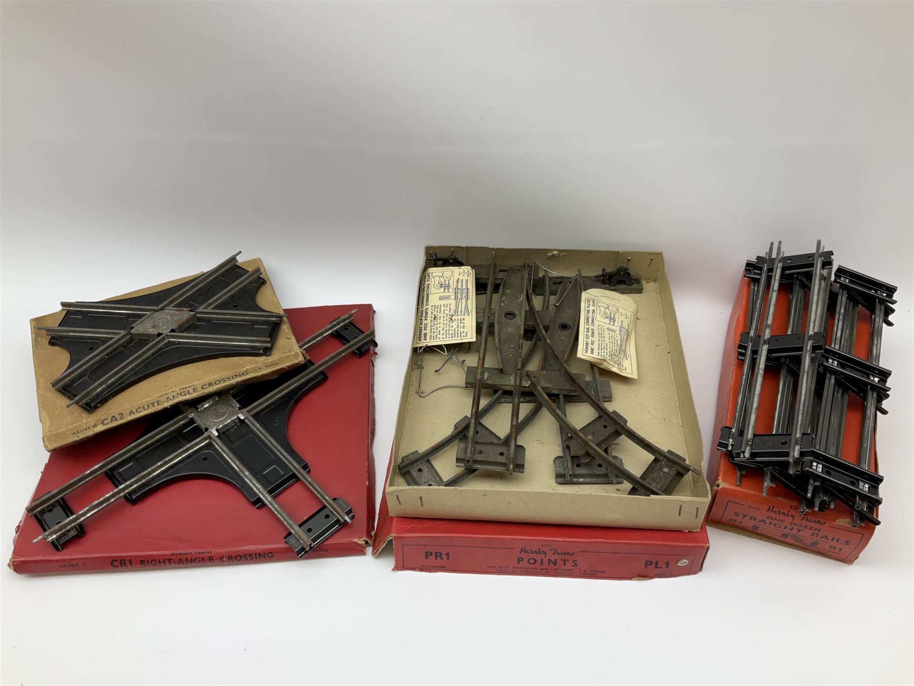 Hornby '0' gauge - layout accessories comprising PR1/PL1 Points, CR1 Right Angle Crossing and CA2 Acute Angle Crossing, all boxed; tin-plate signal box; tin-plate level crossing; textured wooden tunnel, possibly pre-WW2; and quantity of track, some boxed; together with '00' gauge tin-plate station