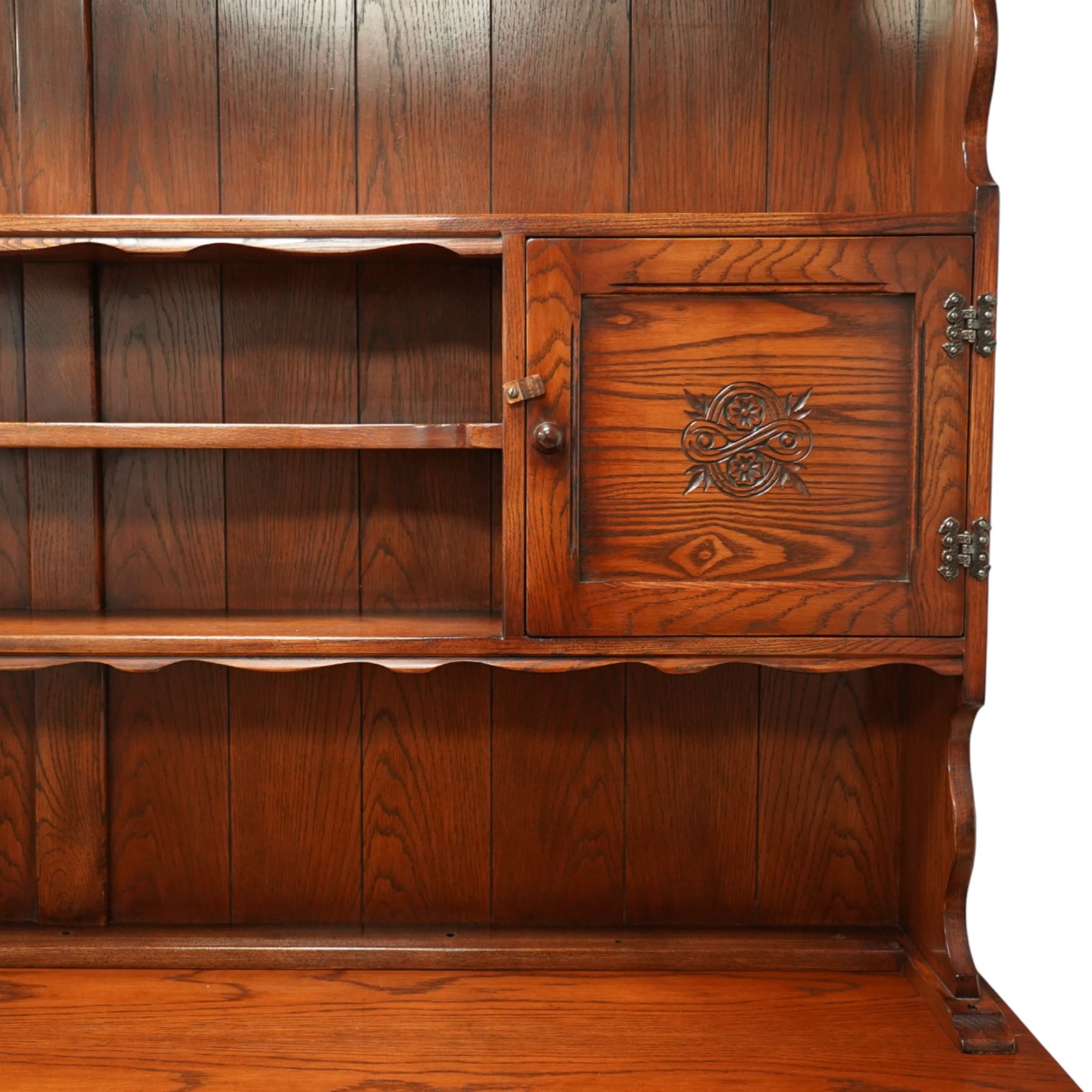 20th century oak dresser, moulded cornice above open plate rack with shaped frieze, flanked by two cupboard doors enclosing shelving, the base fitted with three drawers over three fielded panel cupboard doors, raised on bracket feet