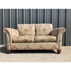 Two seat sofa upholstered in beige patterned fabric, turned supports 