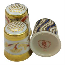 Collection of fifteen Royal Crown Derby thimbles upon an ebonised display stand, together with Royal Crown Derby candle snuffer in Imari pattern 1128