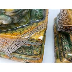 Pair of Chinese Temple Lions or Dogs of Foo, modelled in seated post, one with one front paw resting upon a ball, the other upon a cub, each upon stylised plinth base, H44cm