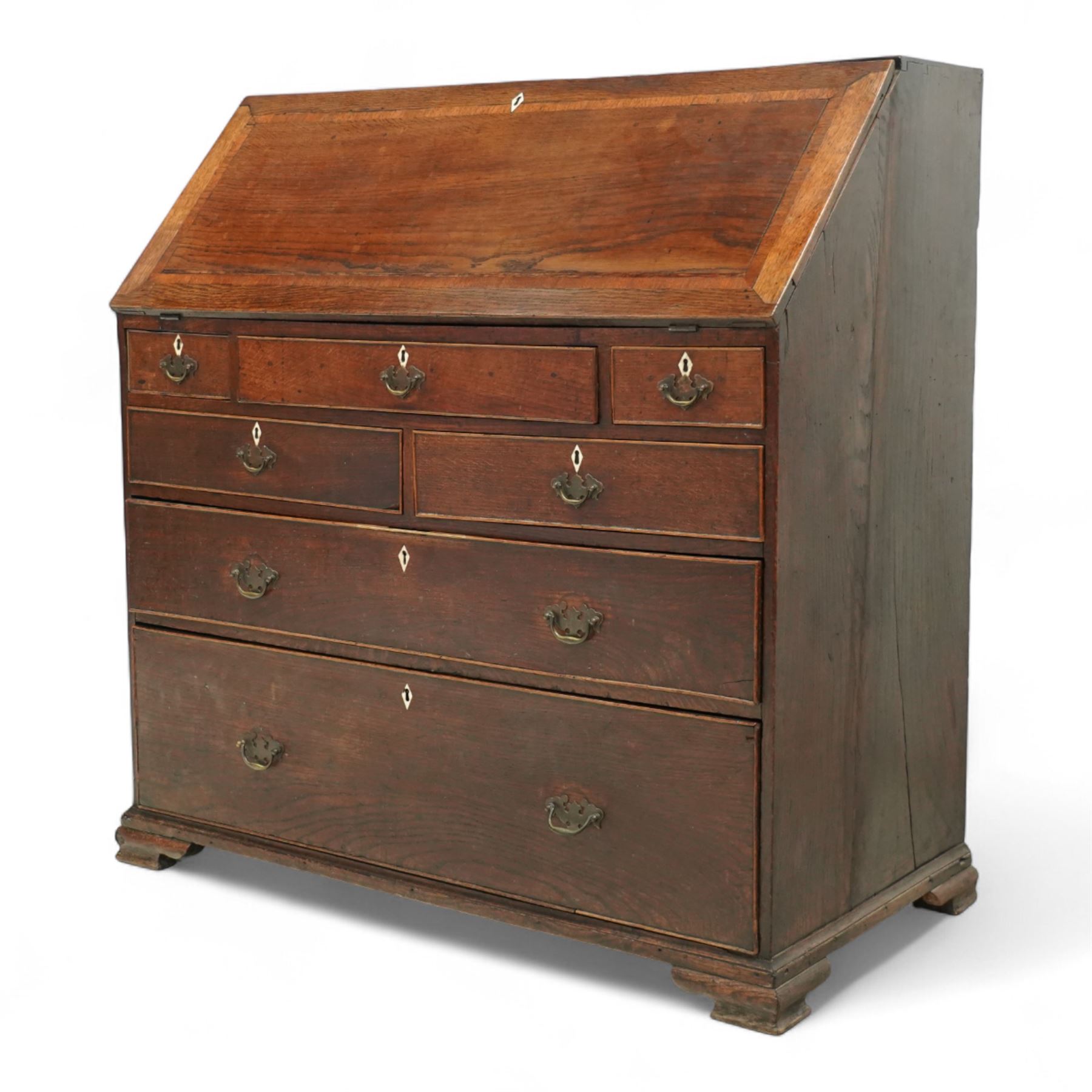 George III oak bureau, the fall front enclosing a fitted interior of small drawers and pigeonholes, above seven graduated drawers with brass plate handles and bone escutcheons, raised on bracket feet