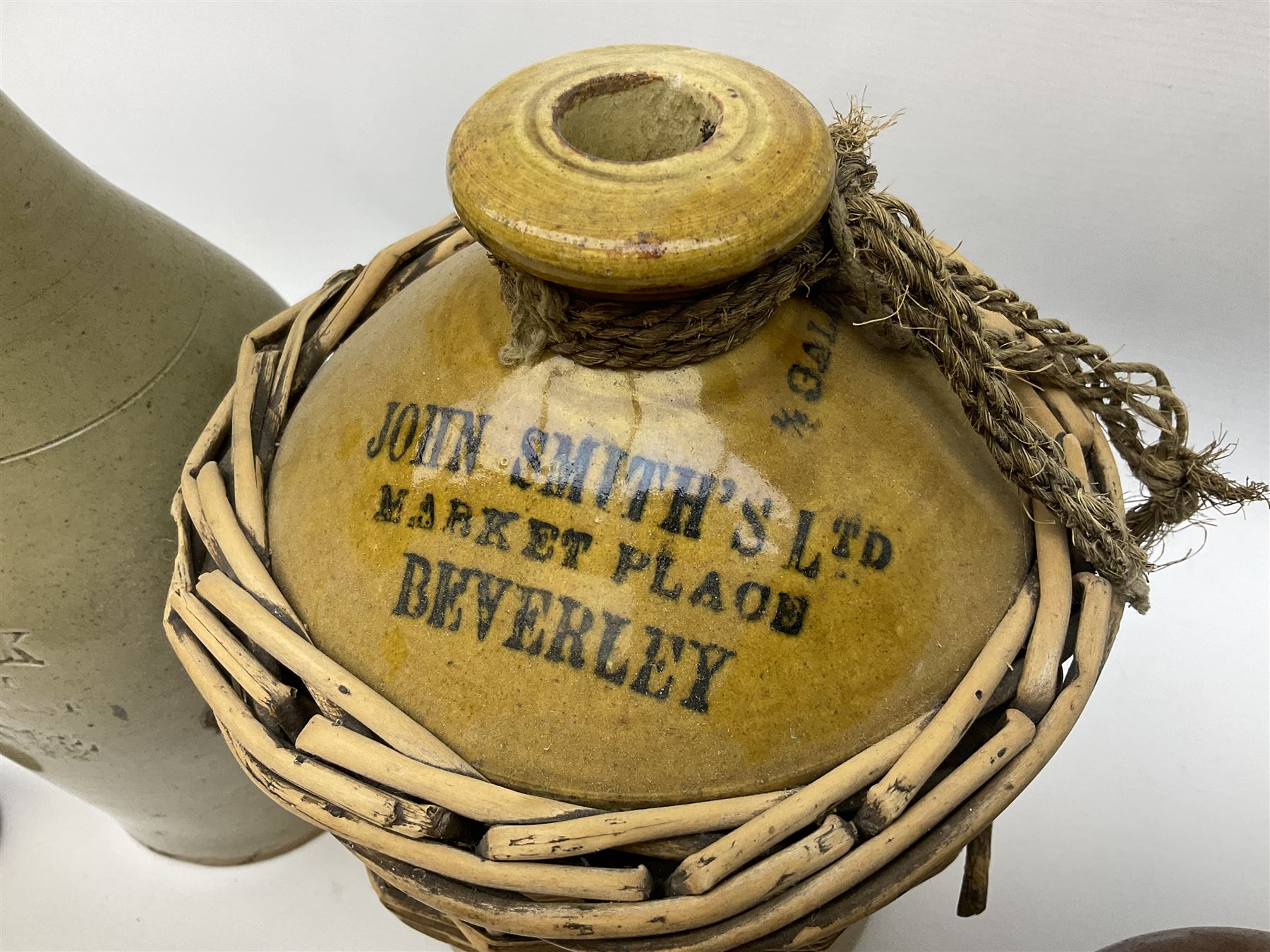 19th century stoneware gin bottle impressed I. Peck, Spirit Merchant Hull H27cm, Victorian salt glazed stoneware jar embossed W. Jefferson Mustard Manufacturer 47 Wincolmlee Hull, part cane covered stoneware flagon for John Smith Market Place Beverley and a Barton-on-Humber stoneware ginger beer bottle (4)  