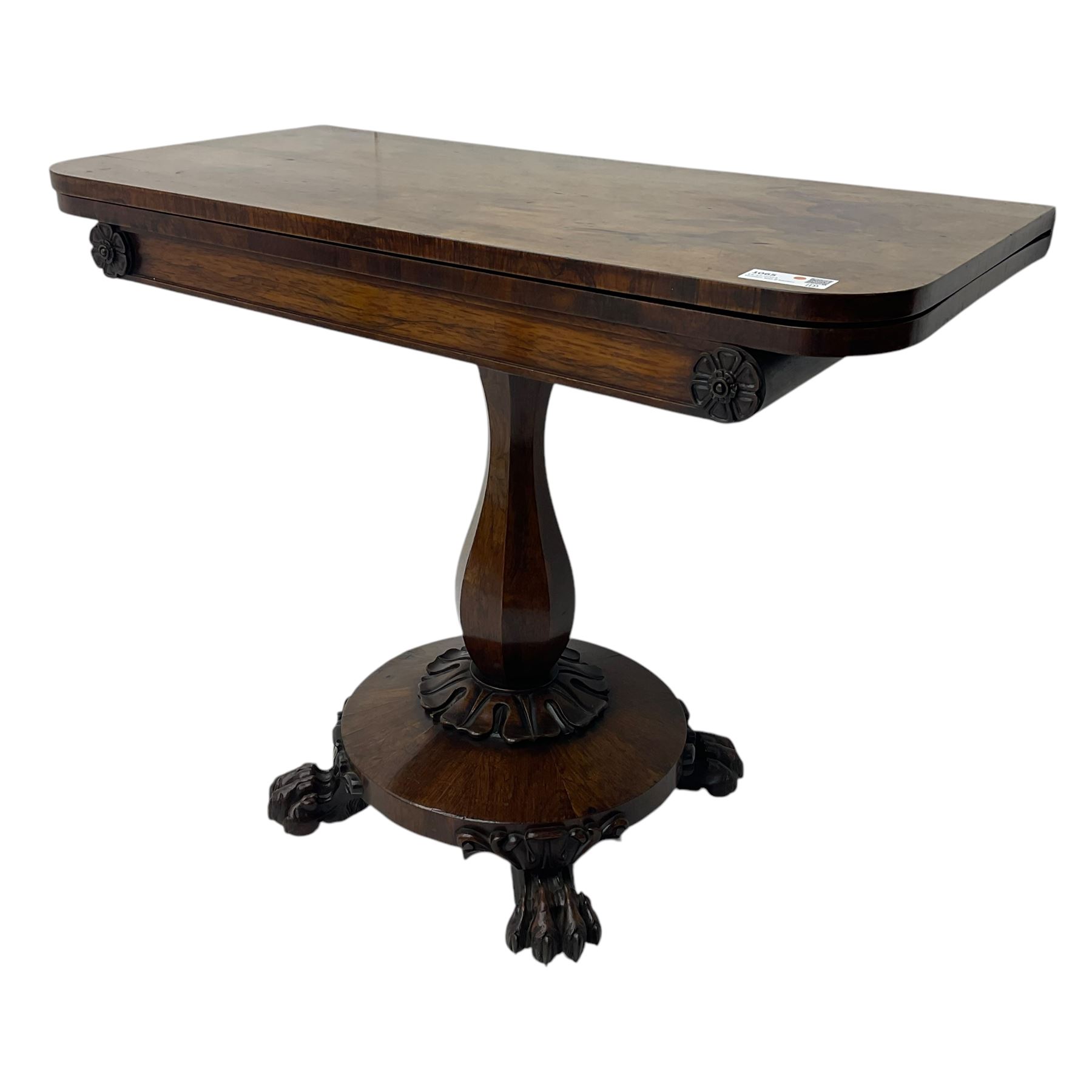 Victorian mahogany tea table, rectangular top with rounded corners, folding and swivelling to reveal interior surface, supported on a faceted baluster-shaped column, raised on a circular platform base with carved acanthus details, ending in four lion paw feet