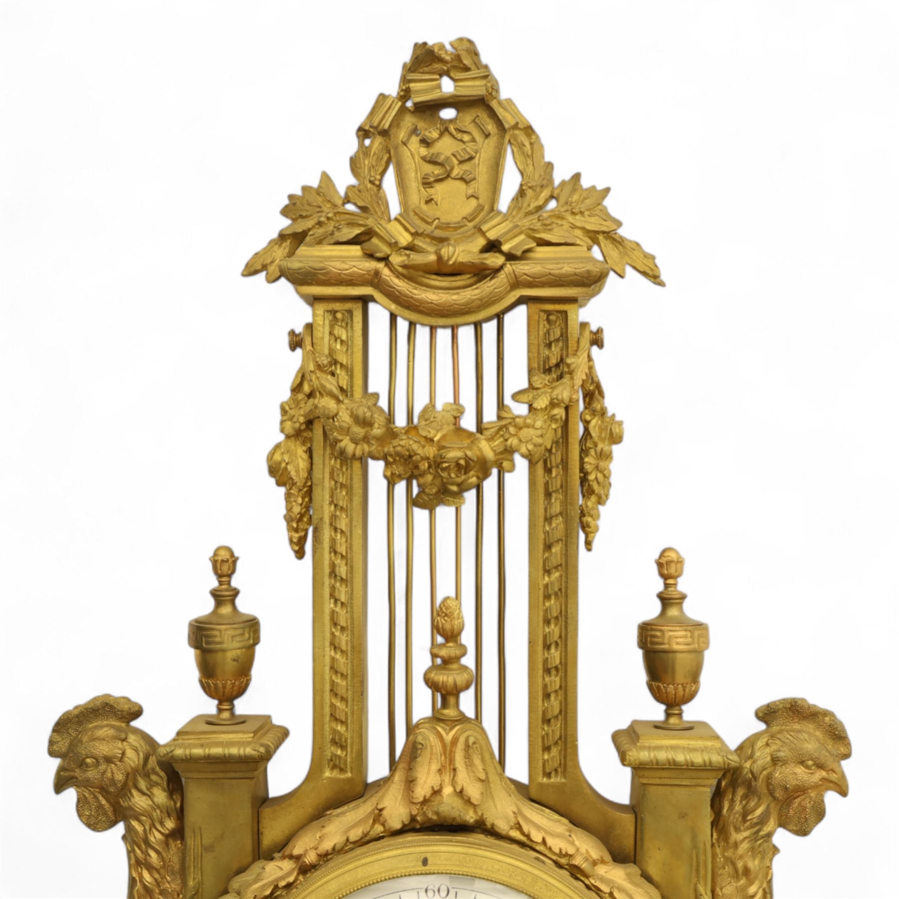 French- late 19th century cast brass and ormolu 8-day cartel wall clock, with a profusely decorated case comprising urn finials garland wreaths, ribbon bows and French cockerels, white enamel dial with minute track, Arabic numerals, garland swags and pierced gilt hands, twin train movement with a recoil anchor escapement and countwheel strike, striking the hours and half-hours on a bell. With pendulum and key.