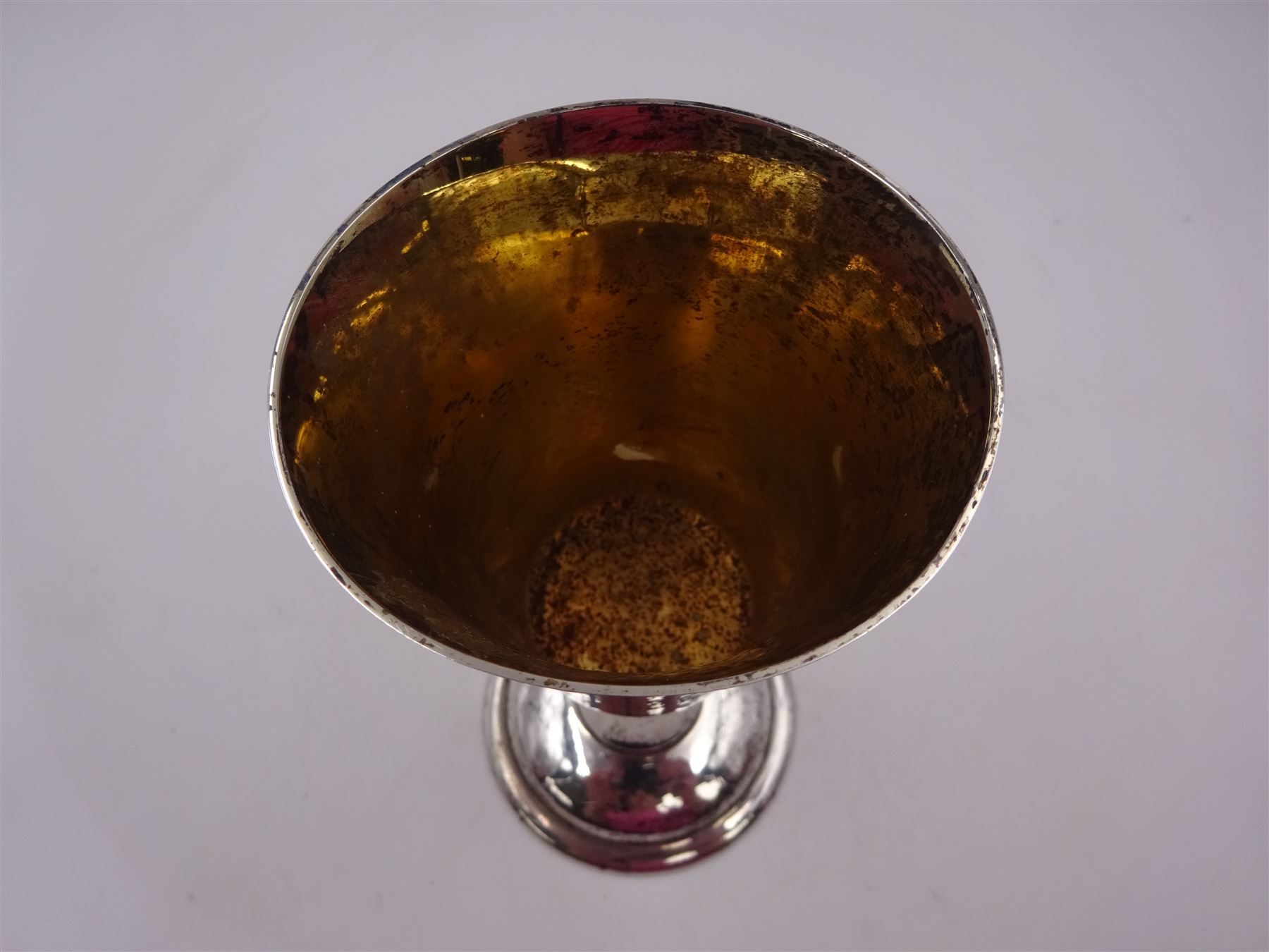 Modern limited edition silver goblet, a replica of the original silver chalice of Lincoln Cathedral, with hand planished decoration, and engraved band of laurel leaves to bowl, with gilt interior, upon waisted stem and circular stepped foot, no. 144/200, hallmarked John Cussell, London 1977, H15cm