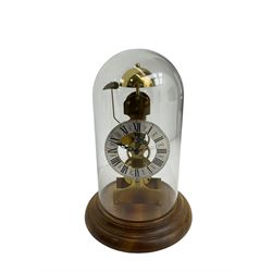 German - Kieninger 20th century 8-day timepiece skeleton clock striking the bell once on the hour, with a silvered chapter ring, Roman numerals and pierced steel hands, mounted on a turned wooden base with a glass dome. With key and pendulum.

