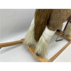 Modern plush covered rocking horse with inset eyes, simulated leather bridle and saddle with metal stirrups, on curving wooden rockers L94cm H64cm