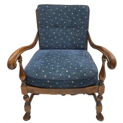 Early 20th century stained beech framed armchair, cane panel back over scrolled arm terminals, raised on turned supports united by turned H-stretcher, with patterned blue upholstered loose back and seat cushions