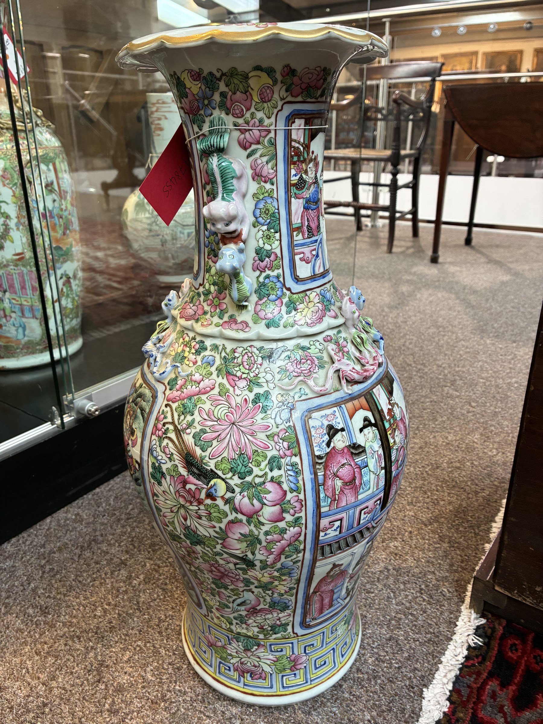 Large pair of 19th century Cantonese famille rose vases, each painted with various courtly scenes, including a display of warriors fighting on horseback before an official and his attendants, double Buddhist lion handles and applied at the shoulders with chilong, the lower band painted with Greek key motif, H58cm (2)