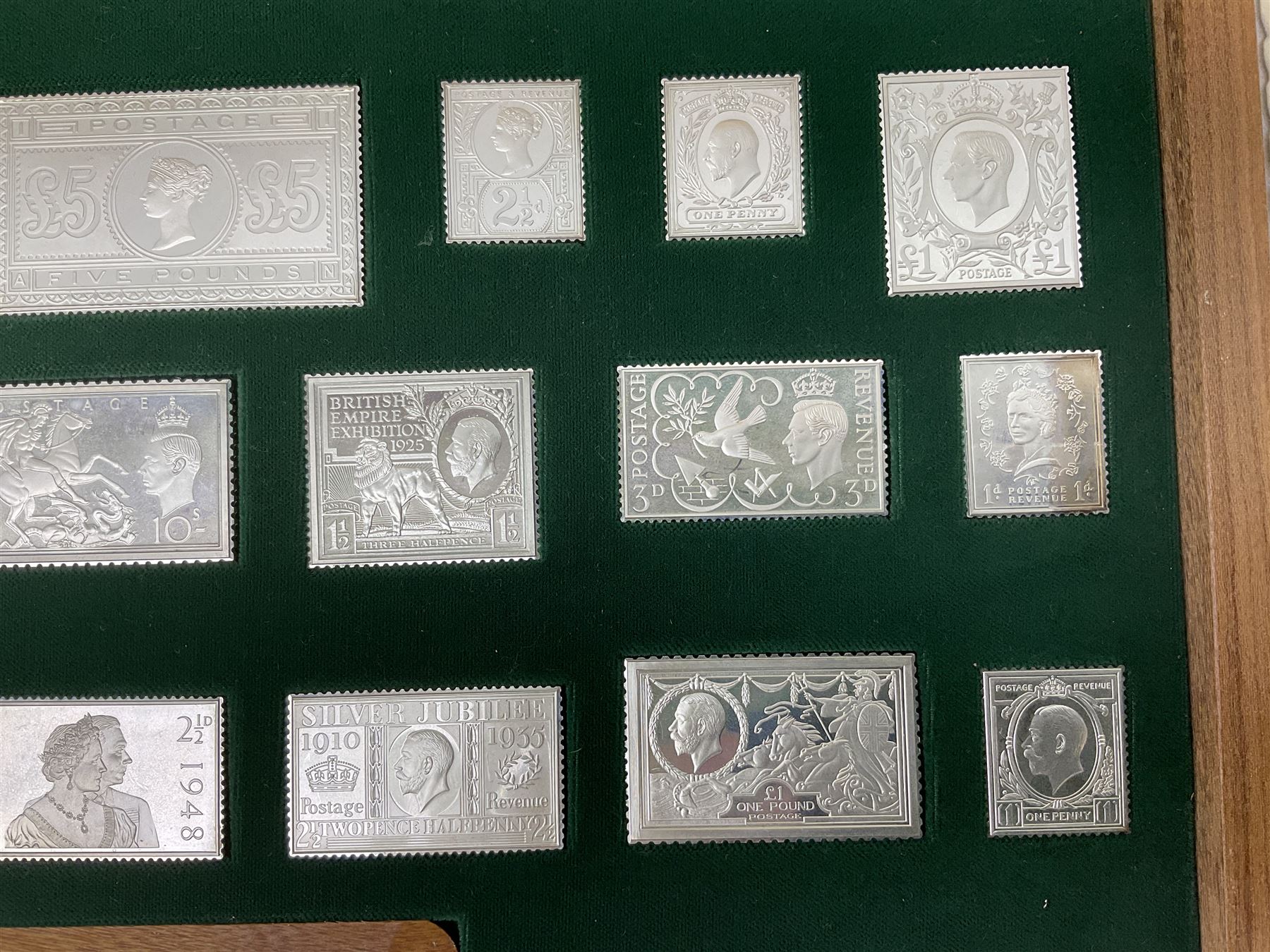 The Stamps of Royalty collection consisting of twenty-five sterling silver hallmarked stamp replicas, housed in a fitted wooden display case, with certificates, polishing cloth and certificates