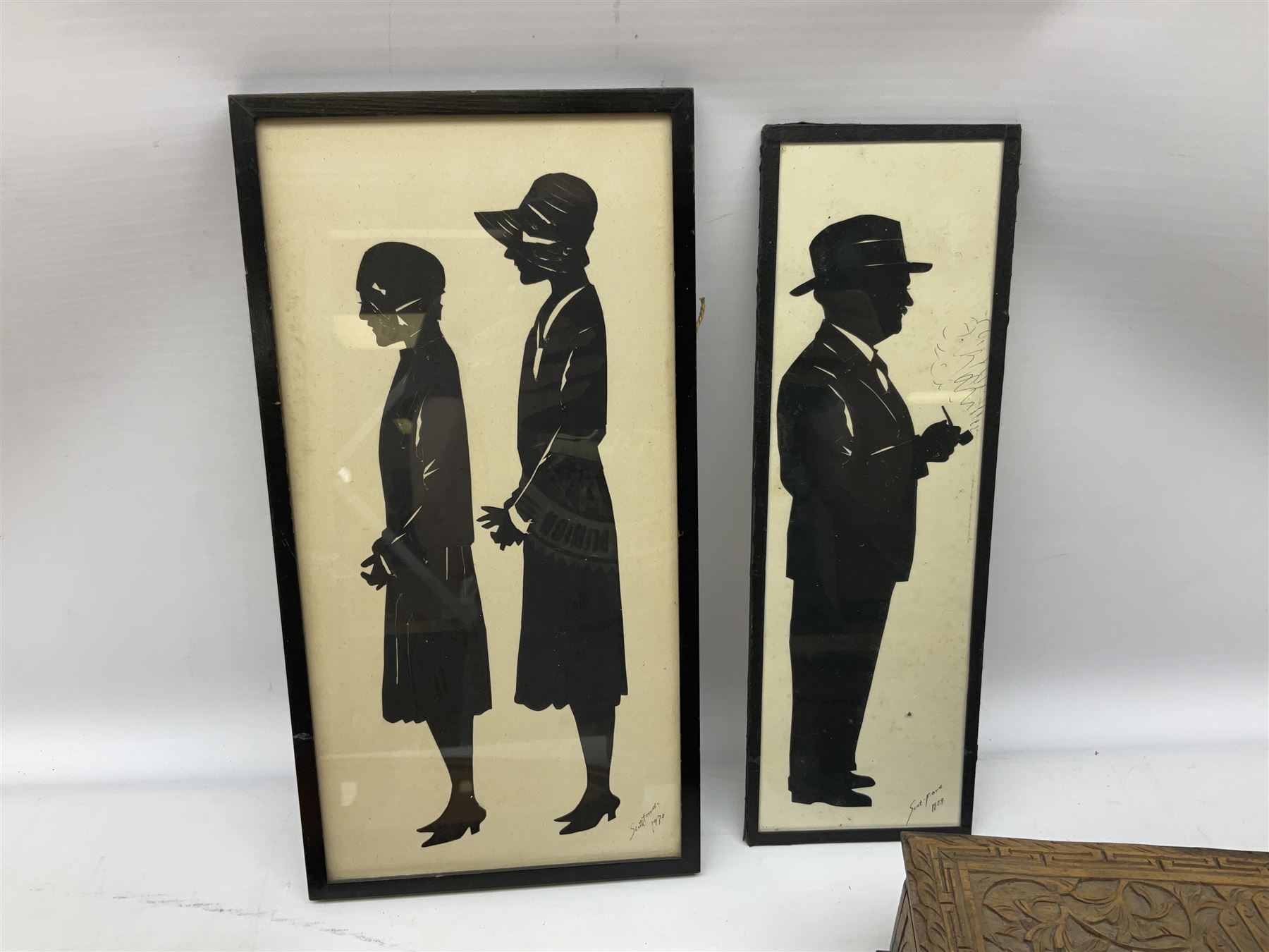 Two Scott-Ford framed silhouettes, featuring the standing profile study of a man dated 1929 and a pair of women dated 1929 and 1930, together with a box containing wooden chess pieces and a serving tray 