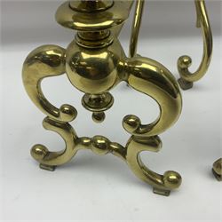Pair of early 20th century brass fire dogs, each with sphere and urn finial, upon a scrolling base, H38cm