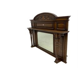Oak overmantle mirror, arched pediment carved with shield and flanking fish with trailing scrollwork, panelled frieze over extending canopy raised by turned and fluted column pilasters, bevelled mirror plate 