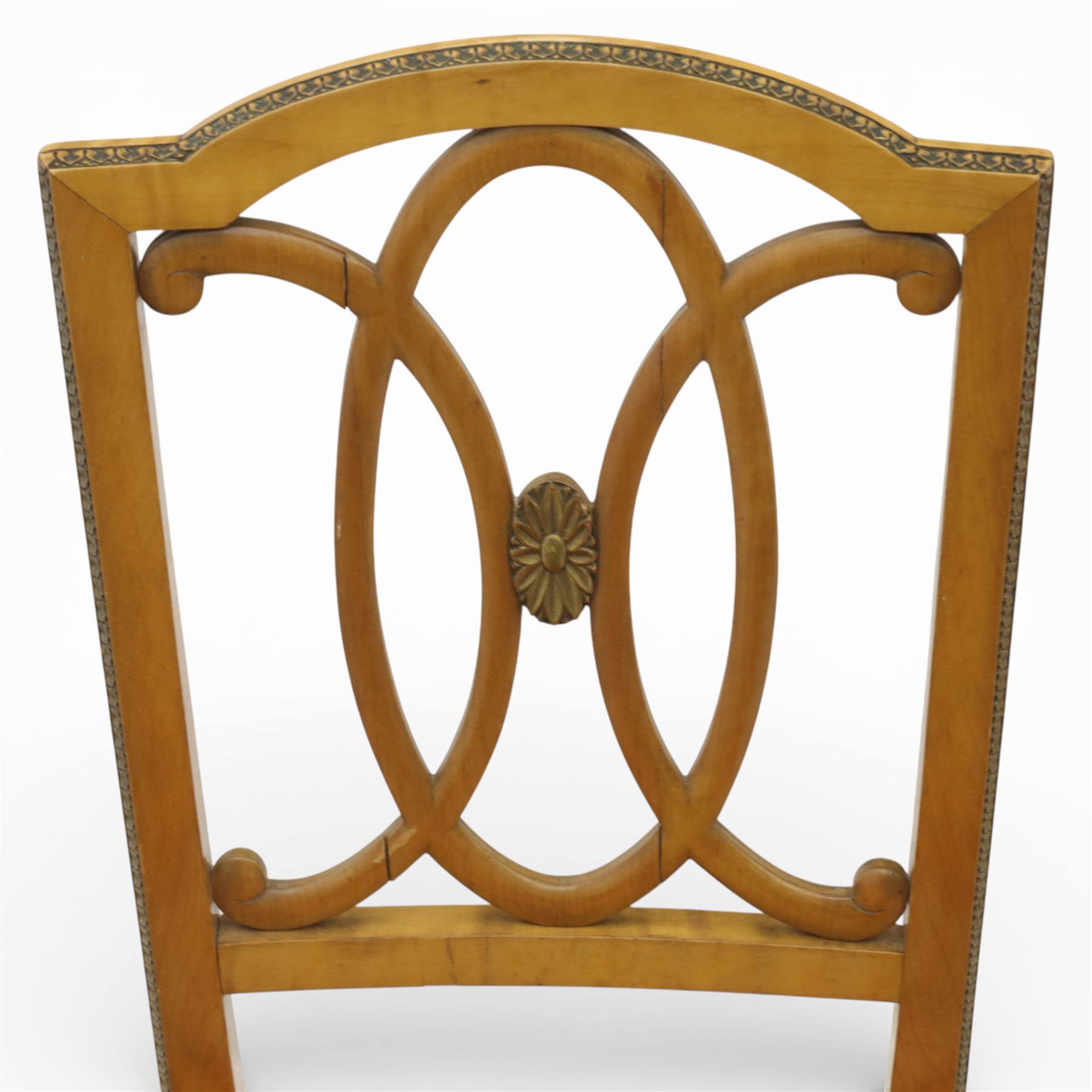 Edwardian pair of satinwood side chairs, each with shaped crest rail above an intertwining oval pierced splats centred by a floral patera, upholstered drop-in seats, raised on cabriole supports with applied floral mounts to the knees