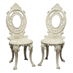  Pair 19th century ornate cast iron garden chairs, oval backs, cream painted  