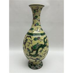20th century Chinese Famille Verte vase, of slender ovoid form with tapering neck and flared rim, decorated with green and grey enamel with dragons chasing flaming pearls amongst auspicious clouds upon a yellow ground, H30cm
