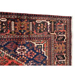 Persian Joshgan red ground rug, the medallion, field and spandrels decorated with clusters of Pitrak and tree of life motifs, the border with repeating design decorated with stylised plant motifs, within guard stripes