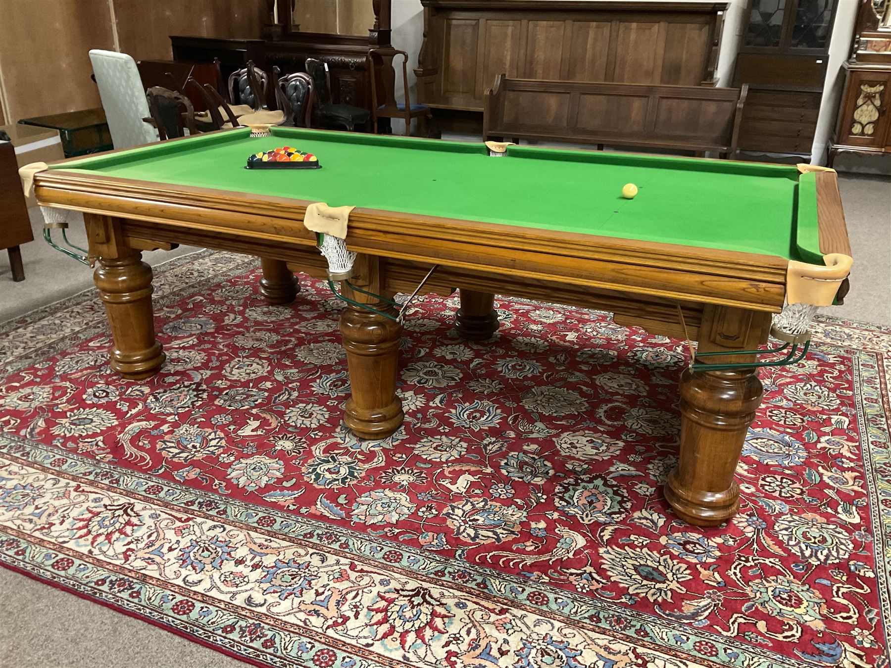 Late 20th century oak slate bed billiard table, on six turned column supports,  together with cues, ball set, baize brush, triangles and scoreboard 