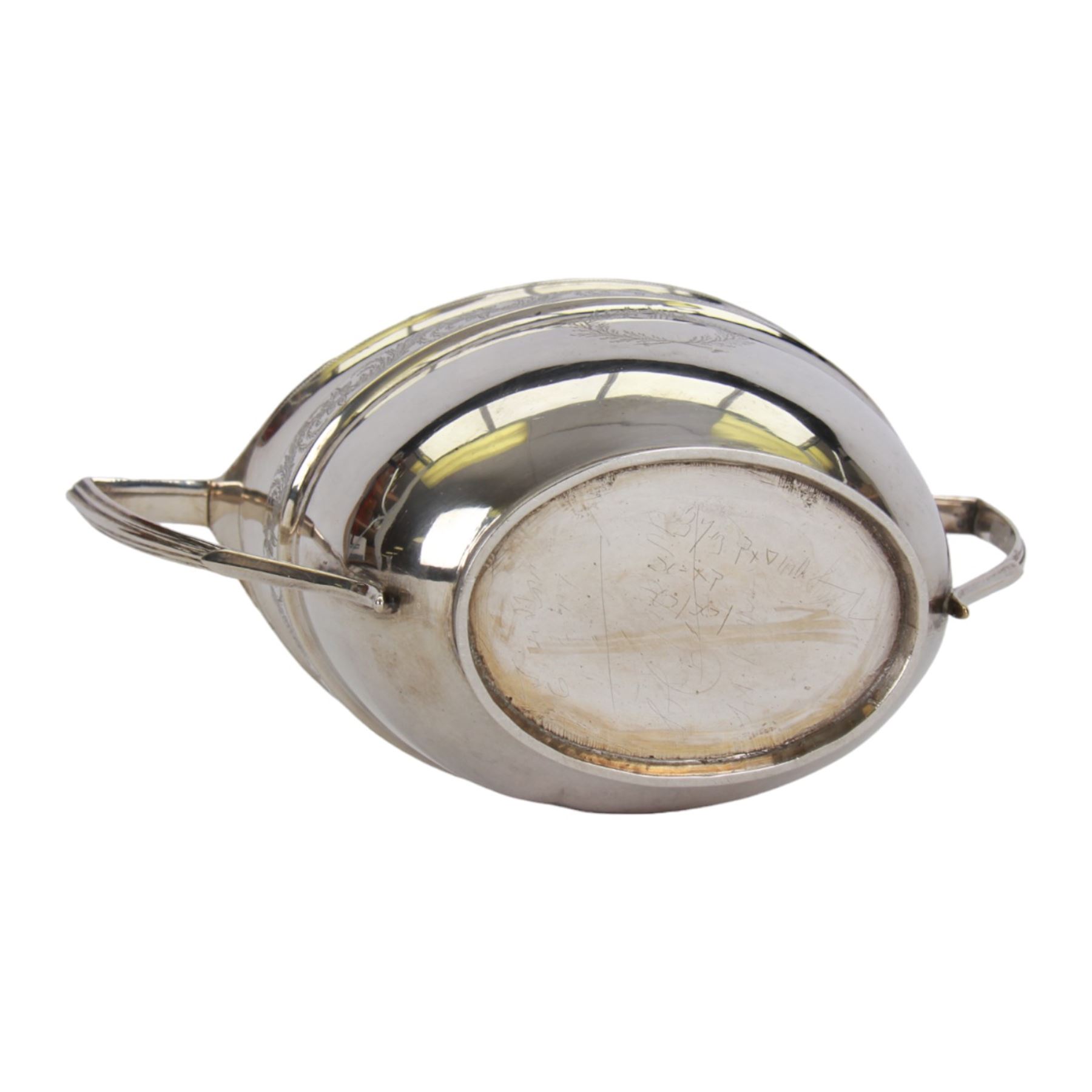 George III silver three piece tea service, comprising teapot with ivory scroll capped curved handle and ivory finial to the hinged cover, twin handled open sucrier with gilt interior, and cream jug with gilt interior, each of oval form with rounded sides, the bodies engraved with central monogram within a seaweed wreath, between engraved foliate bands, hallmarked John Emes, London 1801, teapot including handle H17cm

This item has been registered for sale under Section 10 of the APHA Ivory Act