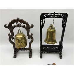Two Chinese table gongs, the brass bells having dragon decoration, housed in carved hardwood frames, along with stick, tallest H40cm