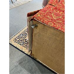 Large Knole design hardwood-framed three-seat drop-arm sofa, upholstered in crimson fabric decorated with trailing acanthus leaves and shields, together with scatter cushions 