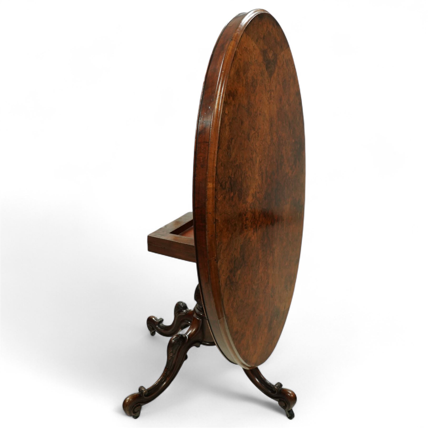 Victorian 19th century burr walnut oval centre table, hinged top above a carved pedestal supported on a scrolled carved quadruped base
