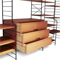 WHB - 'Ladderax' 1960s German modular shelving wall unit, comprising two teak cabinets with white doors, a further fall front teak cabinet with white front, a drawer section with three drawers with recessed handles, multiple shelving sections, raised on metal ladder frames, with further spare sections

Cabinet units: H 47cm, D 36cm, W 71cm
Fall front unit: H 40cm, D 26cm, W 71cm
Shelve widths: 50cm, 71cm 
Shelve depths: 26cm, 36cm