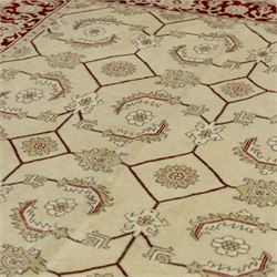 Baluchi signed hand-knotted rug, ivory ground, with an all-over geometric lattice design incorporating stylised flowerheads, hooked motifs and angular vine work, enclosed by a crimson border with repeating floral motifs and scrolling vines, flanked by narrow patterned guard stripes, signed to one corner, with cotton fringes