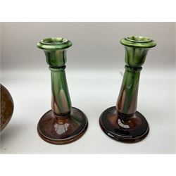 Linthorpe pottery vase with crimped rim and ovoid body, Linthorpe jug with high loop handle and crimped spout, a pair of candlesticks with a green, brown glaze and other similar pottery 