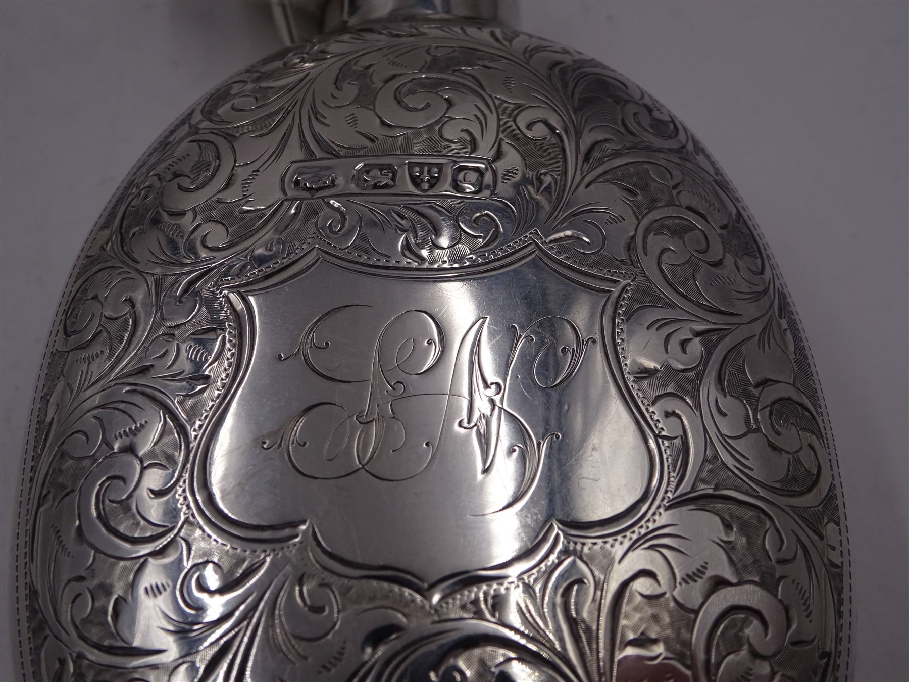 Victorian silver hip flask, of oval form, with engraved foliate and scroll decoration, and monogrammed shield shaped cartouche to centre, with plain collar and cap, H11cm, hallmarked Chester 1899, maker's mark worn and indistinct, together with an Edwardian silver glasses case, of oval form, with engraved foliate and scroll decoration, and monogrammed circular shaped cartouche to centre, with opening to top, revealing velvet lined interior, with silver shield clip, H17.5cm hallmarked to case and clip Sanders & Hill,  Birmingham 1908, with a pair of gold plated glasses 