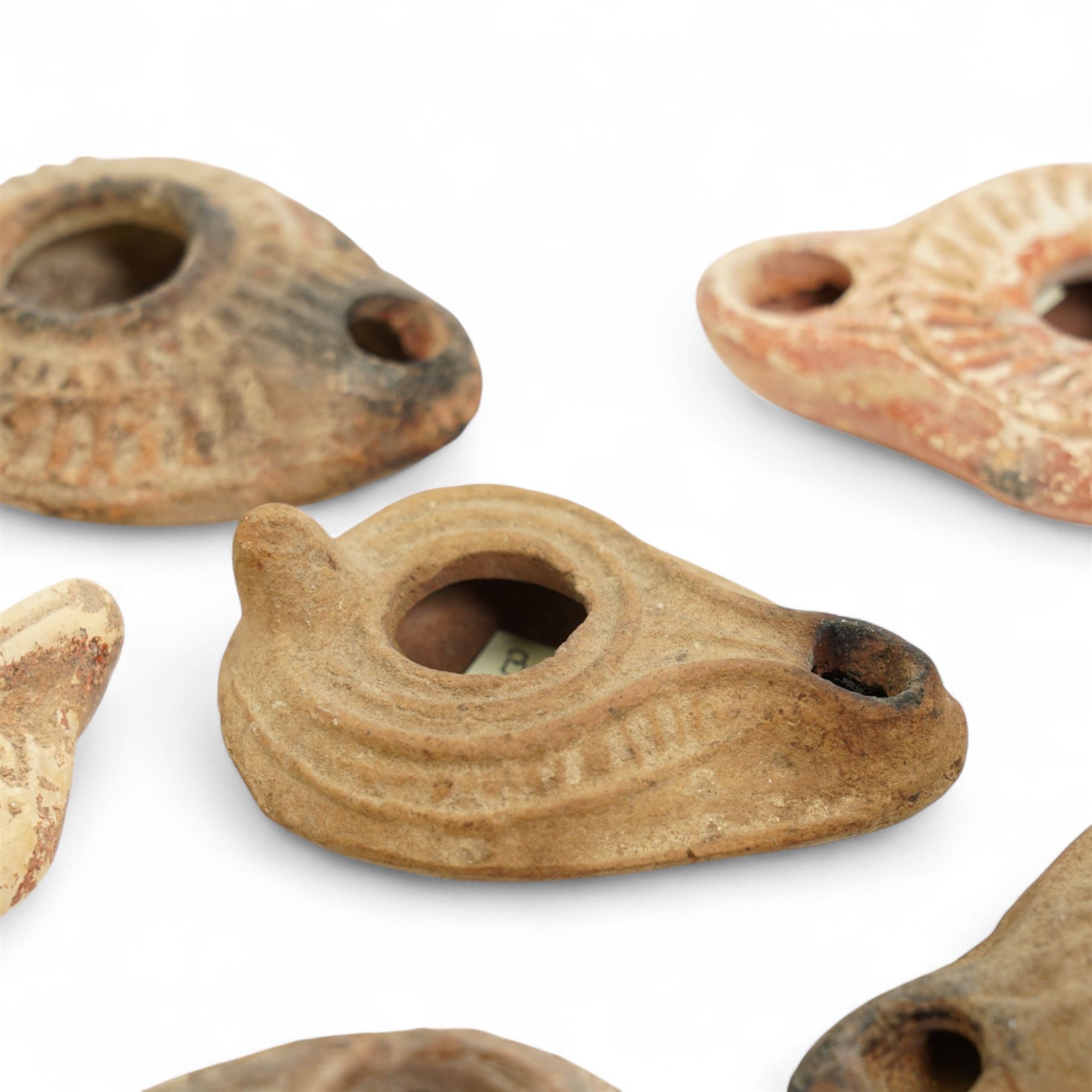 Antiquities; six Byzantine oil lamps, including terracotta examples, approximately 5th-7th century, having incised decoration, largest W10cm (6)