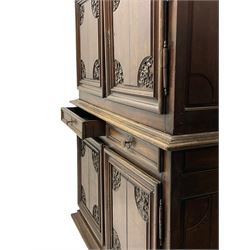 18th century French oak cupboard, projecting moulded cornice over four doors and two drawers, the panelled doors carved with flower heads and foliage, on turned front feet