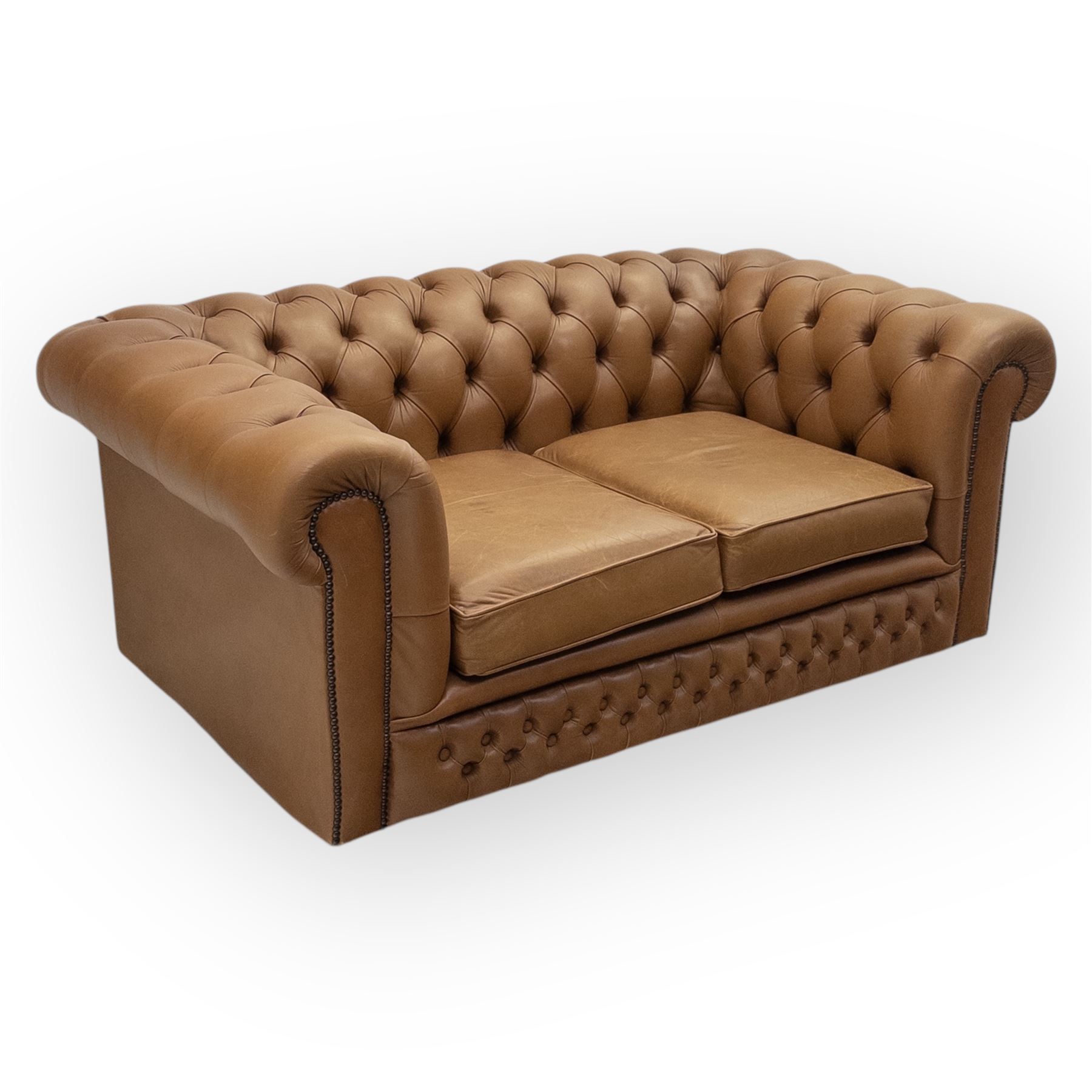 Contemporary tan leather chesterfield settee, deep button upholstered throughout with rolled arms and back of equal height, brass stud detailing, twin seat cushions