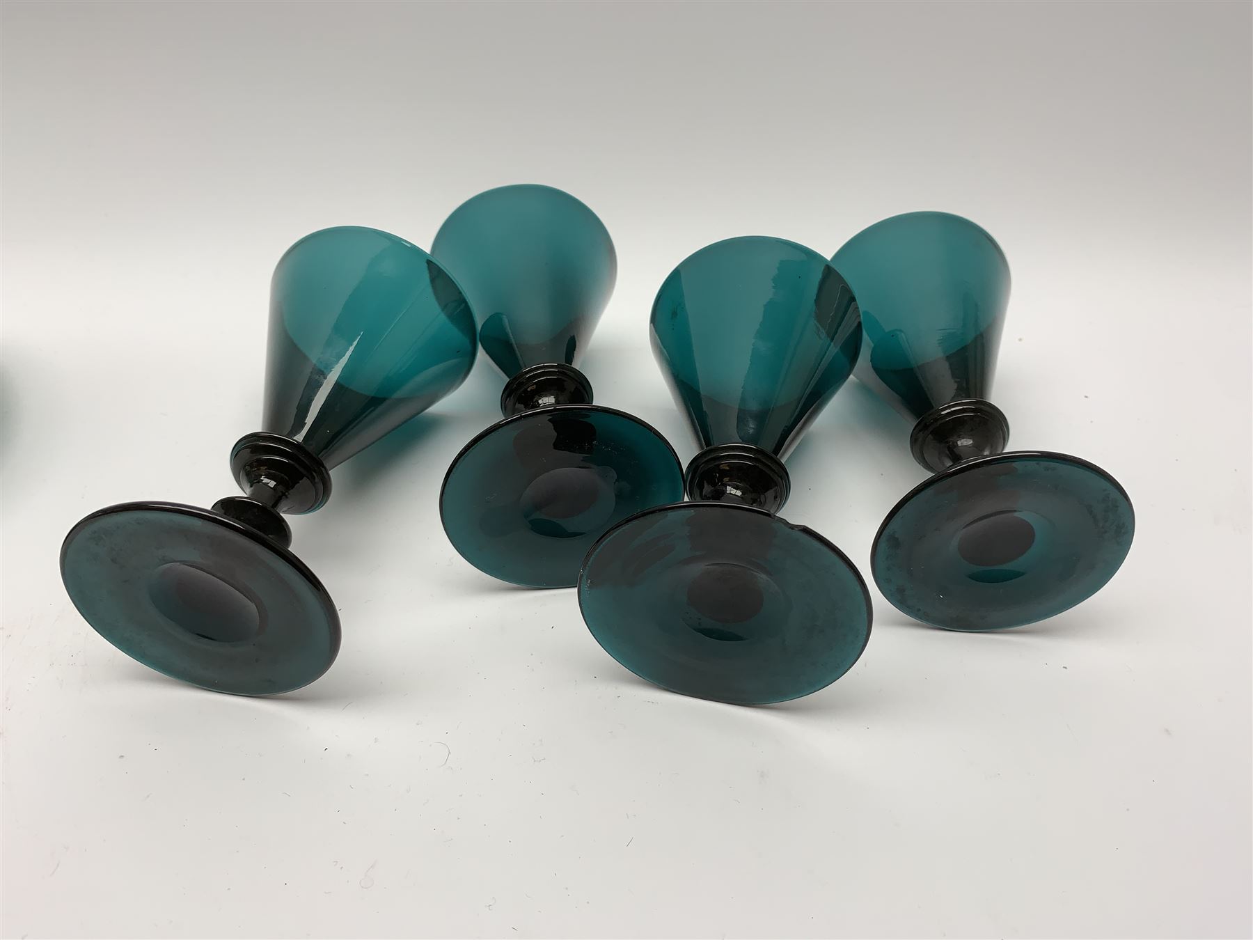 19th century green glass ships decanter with flat topped stopper, H21.5cm, together with a set of four 19th century green glass wine glasses, the funnel bowls upon bladed knopped stems and circular feet, H13cm