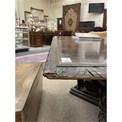 Large 19th century carved oak library table, the rectangular top with lunette carved edge over cartouche panelled and carved  scroll frieze, the central tapering rectangular support relief carved with masks and garlands, on four carved seated lion supports at each corner, on flat angular stretcher with recessed castors stamped ‘Bartholomew & Fletcher, London’