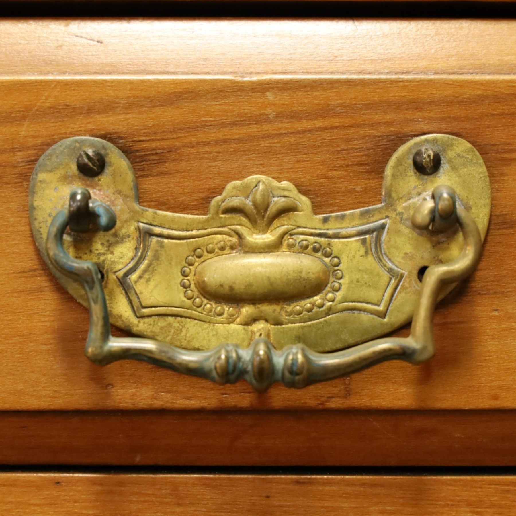Edwardian walnut triple combination wardrobe, projecting pediment with pierced foliate scroll cresting above a central cupboard flanked by bevelled mirrored doors, over open recess with mirrored back, above two short and three long drawers with brass handles, interior fitted with hanging rails and shelf, raised on plinth base